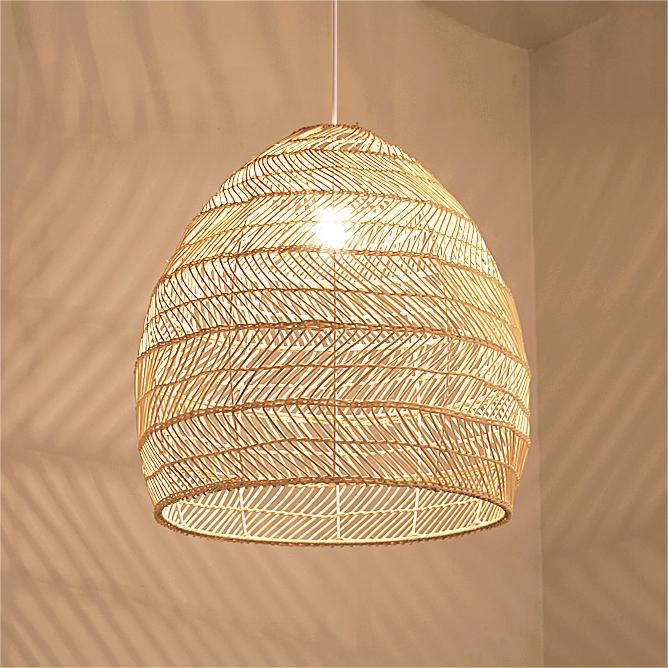 Close-up of woven rattan pendant shade glowing with a warm E27 bulb