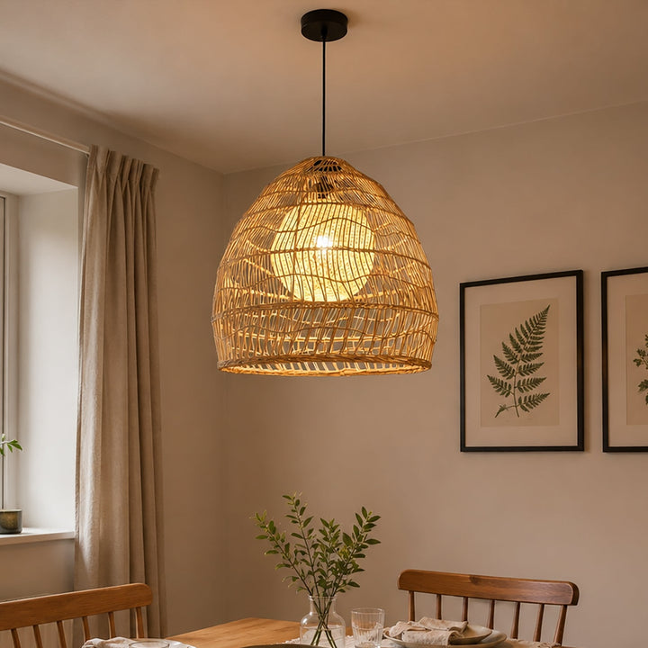 Rattan pendant light with yellow inner sphere above a warm dining table