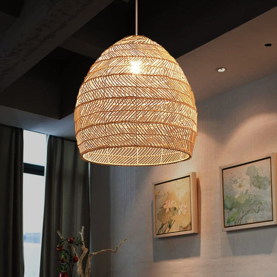 Natural rattan pendant light glowing in a modern art-filled dining room